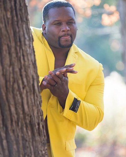 anthony-adams-in-yellow-suit-rubbing-hands